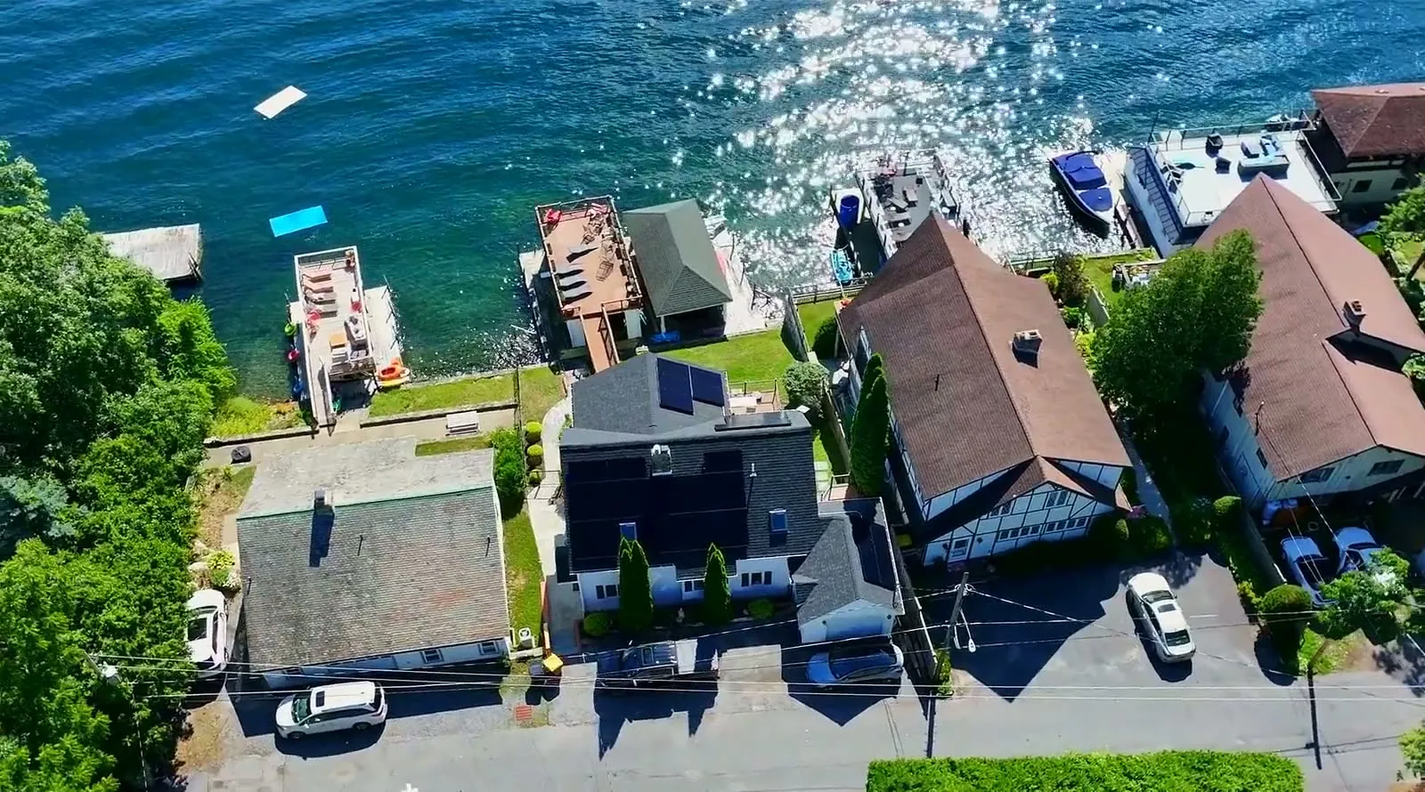 Aerial view of a lakeside home with rooftop solar installed by AEC Solar
